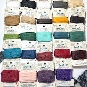 May include: Assortment of 24 spools of waxed Brazilian cord in various colors, including white, black, brown, gray, beige, yellow, green, teal, blue, red, pink, purple, and burgundy. Each spool is labeled "Knot-it!" and includes the length of the cord in yards and meters.