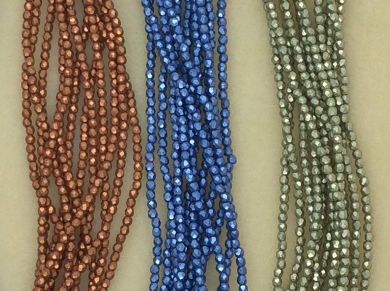 May include: Three strands of faceted glass beads, one copper, one blue, and one green.