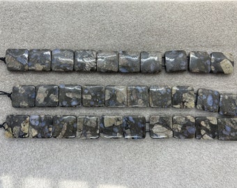 Könnte beinhalten: Drei Stränge quadratischer Edelsteinperlen mit einem schwarzen und blauen Marmormuster. Die Perlen sind auf schwarzen Schnüren mit Knoten an den Enden aufgefädelt.