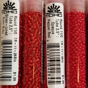 Pode incluir: Tr&ecirc;s tubos de contas de semente vermelhas TOHO. Os tubos s&atilde;o etiquetados com o tamanho das contas, a cor e o pre&ccedil;o. As contas s&atilde;o de tamanho 11/0 e v&ecirc;m em um tubo de 2,5 polegadas. As cores s&atilde;o Vermelho Pimenta, Rubi Slam e Rubi Slam Forrado de Prata.