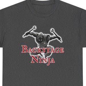 May include: Dark gray t-shirt featuring a ninja graphic with wrenches and the text "Backstage Ninja" in red and white. The ninja is wearing a black outfit and a hood.