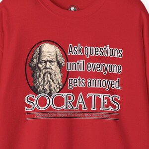 Puede incluir: Camiseta roja con una ilustración blanca de Sócrates, un filósofo griego, y el texto "Ask questions until everyone gets annoyed. SOCRATES Philosophy for People Who Don't Have Time to Read."
