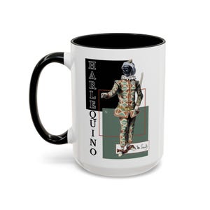 May include: White ceramic mug with a black handle and interior. The mug features a colorful illustration of a Harlequin character in a diamond-patterned costume, with the word "HARLEQUINO" printed vertically.