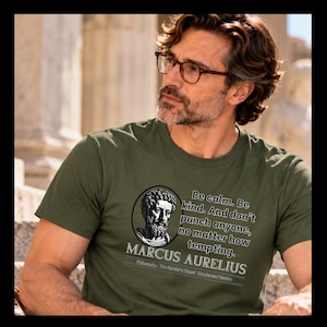 May include: An olive green t-shirt featuring a circular black and white portrait of Marcus Aurelius. The text reads: Be calm. Be kind. And don't punch anyone, no matter how tempting. MARCUS AURELIUS. Philosophy: The Reader's Digest Condensed Books.