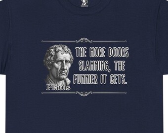 May include: Navy blue t-shirt featuring a white graphic of a bust of a man and the quote, "THE MORE DOORS SLAMMING, THE FUNNIER IT GETS." The name "Platus" is below the bust. The shirt has a crew neck and short sleeves.