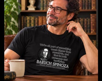 May include: A black short-sleeved t-shirt featuring a circular portrait of Baruch Spinoza, the text "We're all part of something much bigger than ourselves, and that is both awesome and terrifying.", "BARUCH SPINOZA", and "Philosophy: The Reader's Digest Condensed Version."