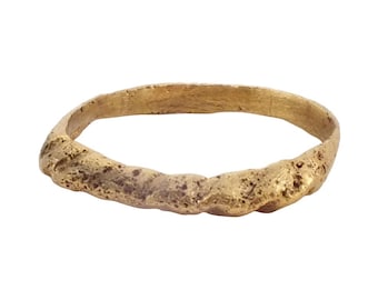 May include: A simple gold band ring with a textured surface.