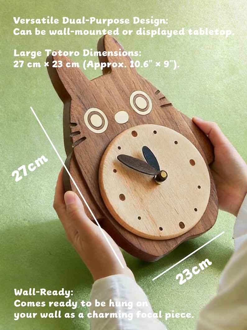 May include: Wooden Totoro-shaped clock, wall-ready. The clock features a light wood clock face with dark hands and a dark wood Totoro outline. Dimensions are approximately 10.6" x 9". The clock can be wall-mounted or displayed on a tabletop.