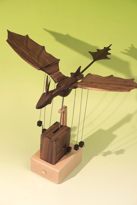A handcrafted wooden dragon automaton with visible moving mechanical parts — the 'fantasy desk pet' framing is exactly right for the right person.
