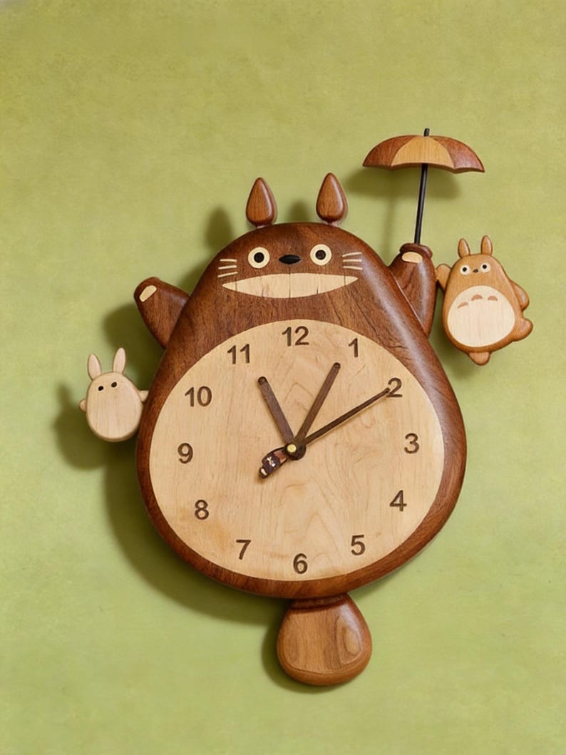 May include: A wooden wall clock shaped like a large brown creature with pointed ears, holding a small umbrella and two smaller light-coloured figures on its sides. The clock face is circular and light-toned with black numbers from 1 to 12.