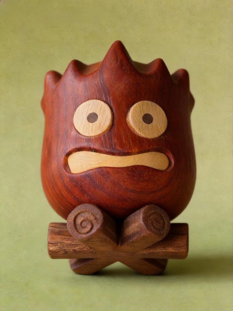 May include: A handcrafted wooden figure with a surprised expression. The figure is reddish-brown with light-colored eyes and mouth. It sits atop a cross-shaped base made of darker wood, resembling a campfire.