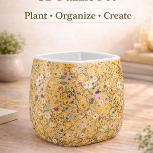 May include: A white ceramic mug with a black handle and the text "But First, Coffee" in a handwritten style. The mug is on a white surface. The mug is approximately 4 inches tall.