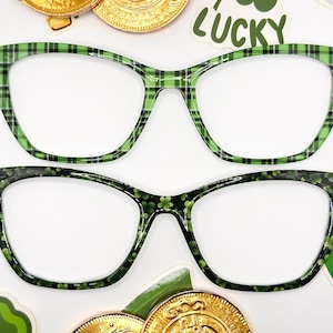 May include: Two pairs of green and black patterned glasses. The top pair has a plaid pattern and the bottom pair has a shamrock pattern.