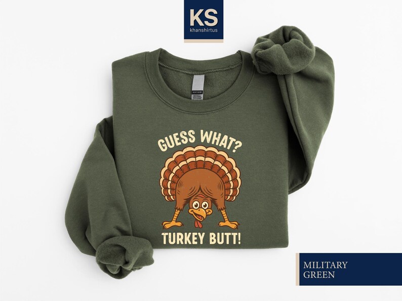 A green sweatshirt with a cartoon turkey and the text "Guess What? Turkey Butt!" printed on it.