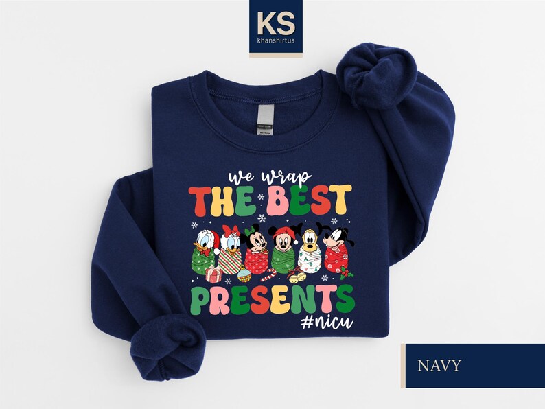 A navy blue sweatshirt with a colorful graphic design featuring Disney characters and the text "we wrap the best presents #nics".