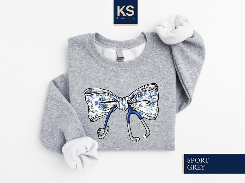 May include: A gray sweatshirt with a blue stethoscope and a white bow with a blue floral pattern. The text "SPORT GREY" is in the bottom right corner of the image.