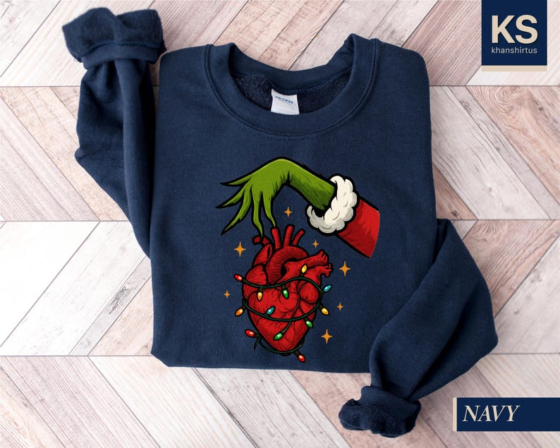 A navy blue sweatshirt with a graphic design depicting a hand holding a heart with Christmas lights around it.