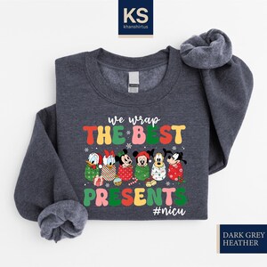 A gray sweatshirt with a colorful graphic design featuring characters from Disney and the text "We wrap the best presents #niscu" printed on it.