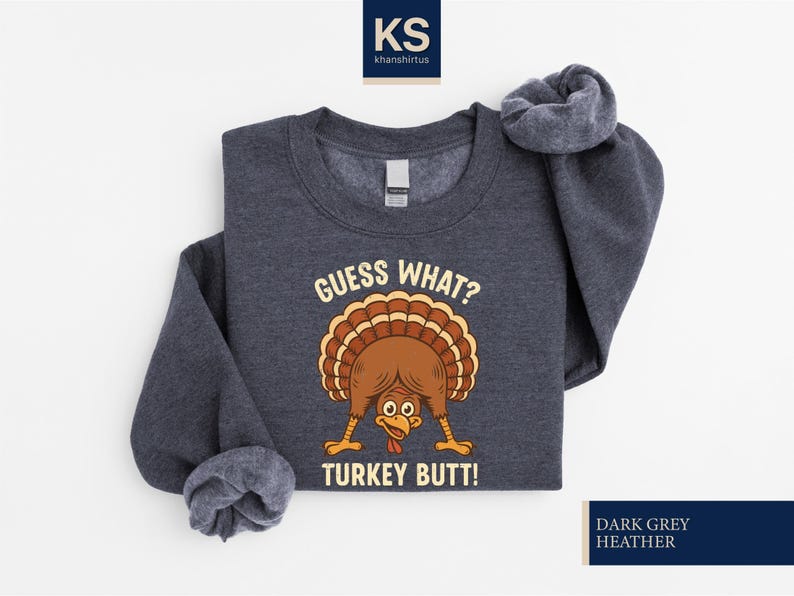 A gray sweatshirt with a graphic of a turkey and the text "Guess What? Turkey Butt!" printed on it.