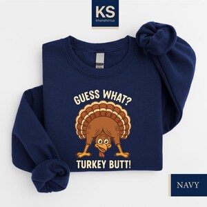 A navy blue sweatshirt with a graphic of a turkey and the text "Guess What? Turkey Butt!" printed on it.