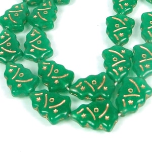 May include: A strand of green glass Christmas tree beads with gold accents. The beads are strung together and ready to be used for crafting or decorating.