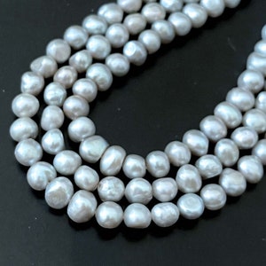 May include: A strand of gray freshwater pearls, strung together in a triple row necklace.