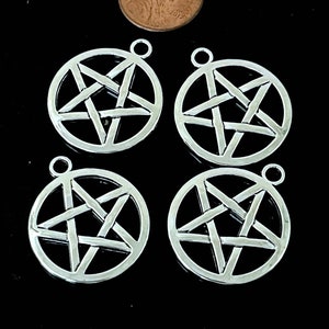 May include: Four silver-toned metal charms in the shape of a pentagram, each with a five-pointed star design. The charms are approximately the size of a US penny.