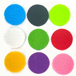 May include: Nine felt circles in a variety of colours: blue, black, green, white, red, yellow, purple, and pink. A penny is included for size reference. The circles are arranged on a white surface. The felt circles are approximately 2.5 cm in diameter.