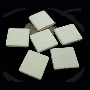 May include: Six off-white square ceramic tiles with a hole in the center of each tile.