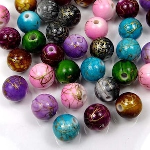 May include: Assortment of colorful round beads with gold accents. The beads are made of wood and have a variety of patterns and designs.