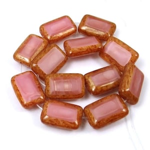 May include: A strand of pink and brown glass beads. The beads are rectangular and have a translucent, iridescent finish.