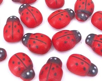 May include: A collection of 20 red and black ladybug shaped wooden craft embellishments. The ladybugs have black spots and white undersides.