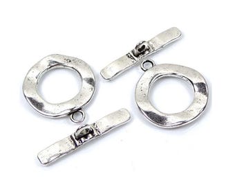 May include: Silver-toned metal toggle clasp with a round, textured loop and a straight bar. The clasp is designed for jewelry making or other craft projects.