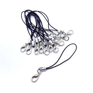 May include: A bundle of black string keychains with silver lobster clasps. The keychains are approximately 2 inches long.