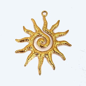 May include: Gold-toned metal pendant featuring a sunburst design with a spiral in the centre. The pendant has a textured surface and a loop at the top for attaching a chain.