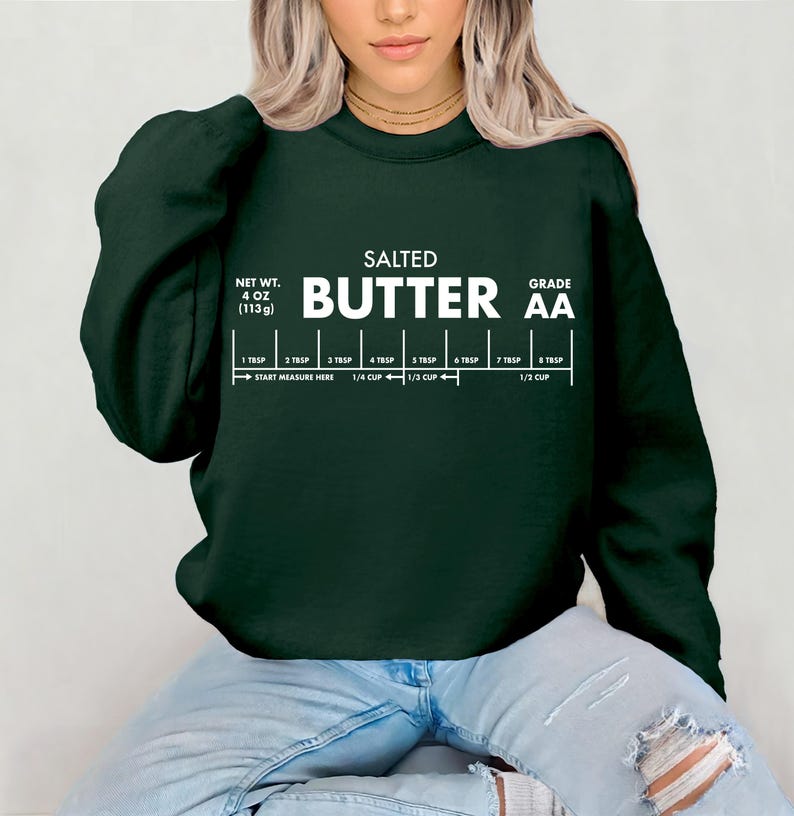 May include: Dark green sweatshirt with white text that reads "SALTED BUTTER AA". The text includes a measurement guide with tablespoons and cup measurements. The net weight is listed as 4 oz (113g).