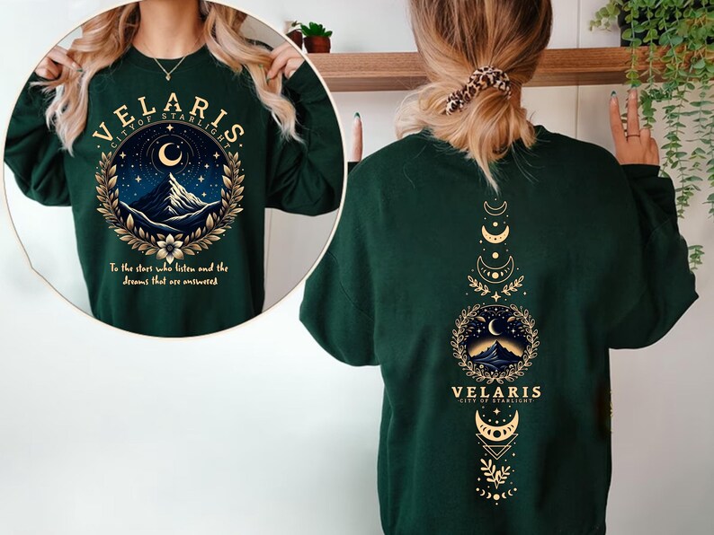 May include: Green long-sleeved sweatshirt with a gold graphic print of a mountain range and crescent moon with the text "VELARIS CITY OF STARLIGHT" and "To the stars who listen and the dreams that are answered". The back of the sweatshirt has a gold graphic print of a mountain range, crescent moon, and stars with the text "VELARIS CITY OF STARLIGHT".
