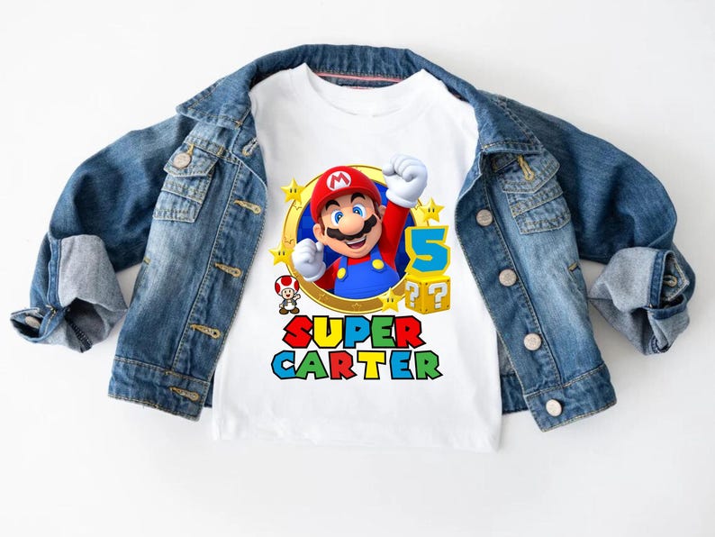 May include: White t-shirt with a colorful graphic of Super Mario, a star, and the text "SUPER CARTER".