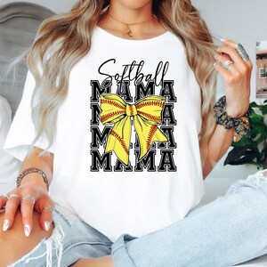 K&ouml;nnte beinhalten: Wei&szlig;es T-Shirt mit dem Text "Softball Mama" in schwarzen Buchstaben und einer gelben und roten Softball-Schleife.