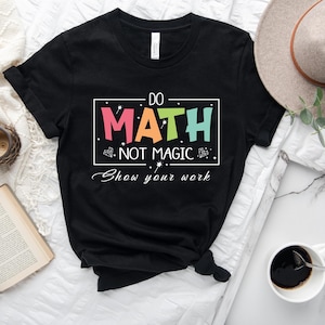 May include: Black t-shirt with the text "Do Math Not Magic Show your work" in a colorful rainbow font.