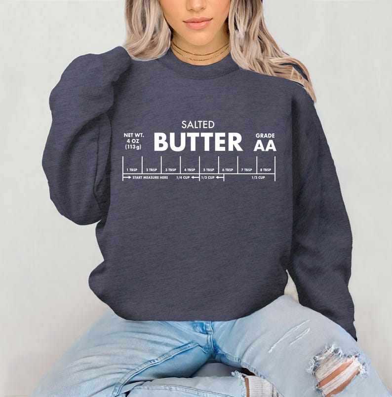 May include: A navy blue sweatshirt with the words "SALTED BUTTER AA" printed in white. Below the text is a butter measurement guide, with measurements from 1 tablespoon to 1/2 cup. The net weight is 4 oz (113g).