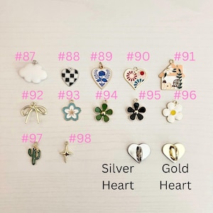 May include: A collection of decorative charms in various shapes and colors, including a cloud, hearts, flowers, a house, a bow, a cactus, and a cross. The charms are labeled with numbers and the words "Silver Heart" and "Gold Heart".