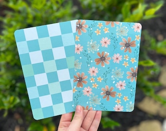 May include: Two decorative cards with different patterns. One card has a blue and white checkered pattern. The other card has a floral pattern with brown, pink, and yellow flowers on a light blue background.