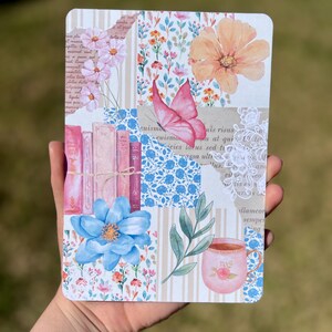 May include: A collage style notebook cover with a pink butterfly, flowers, a cup of tea, and books. The background is a patchwork of floral patterns, stripes, and text.