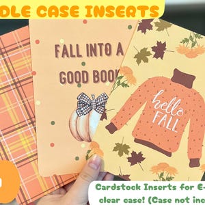 May include: Three cardstock inserts for e-reader clear cases. One features a plaid pattern, another has a pumpkin and the text "Fall into a good book", and the third has a sweater graphic with "hello FALL".
