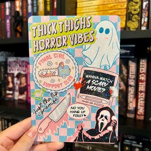 May include: A rectangular sticker with a light blue and pink checkered background featuring horror-themed illustrations and text including "THICK THIGHS HORROR VIBES," "FINAL GIRL SUPPORT CLUB," "WANNA WATCH A SCARY MOVIE?," "JUST THE TIP I PROMISE," and "NO YOU HANG UP FIRST."