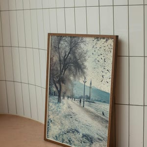 Tranquila escena invernal en Izmir: sendero costero nevado con majestuoso minarete y pájaros en vuelo, póster de arte mural con un paisaje turco sereno