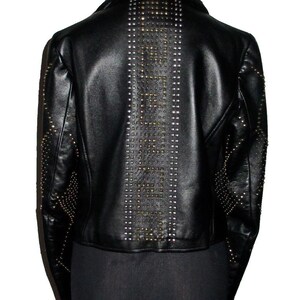 May include: Black leather jacket with a studded design. The studs are arranged in a vertical line down the back of the jacket.