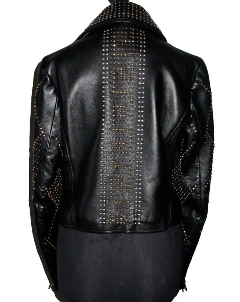 May include: Black leather jacket with a studded design. The studs are arranged in a vertical line down the back of the jacket.