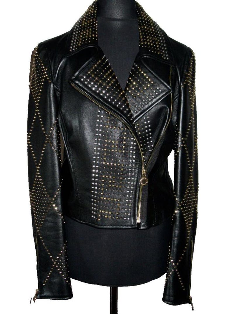 May include: Black leather jacket with gold studs. The jacket has a zip fastening and a collar.